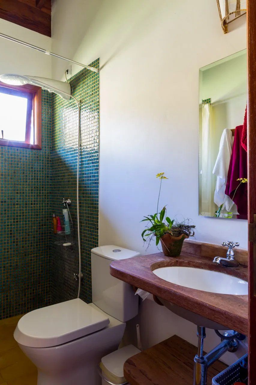 Um banheiro com vaso sanitário, pia e chuveiro.