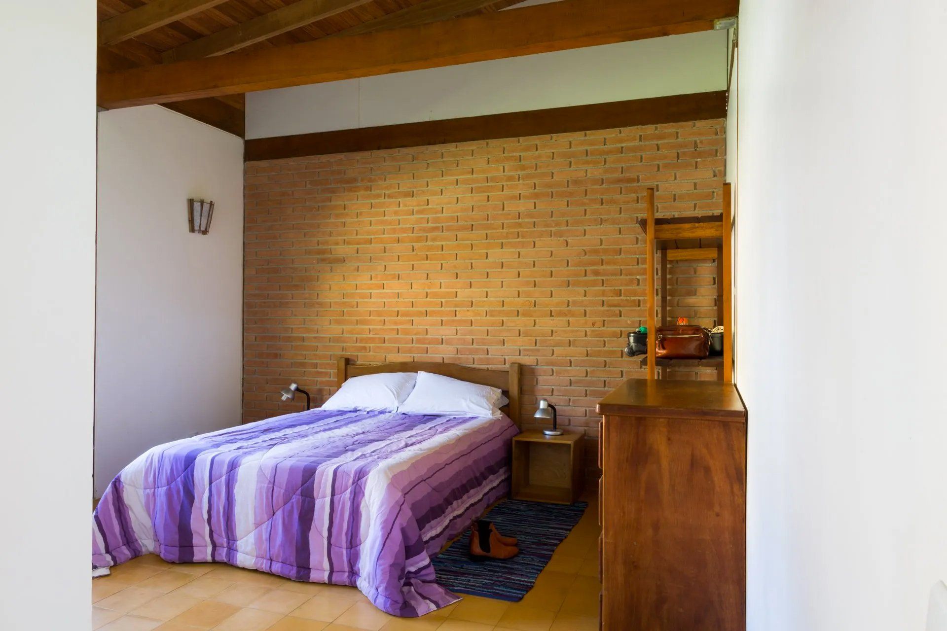 Um quarto com uma cama e uma parede de tijolos