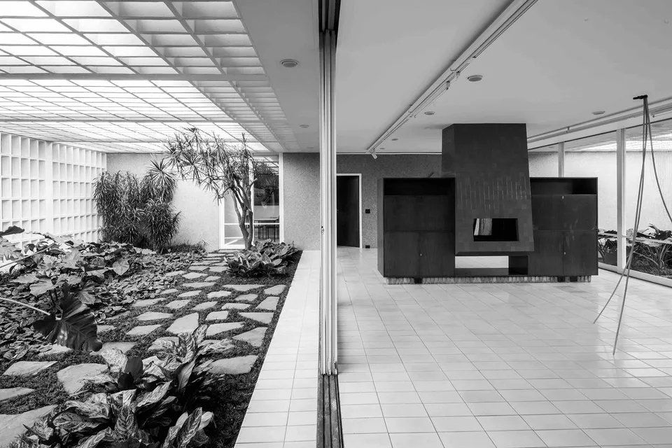 Uma foto em preto e branco de uma sala de estar com lareira