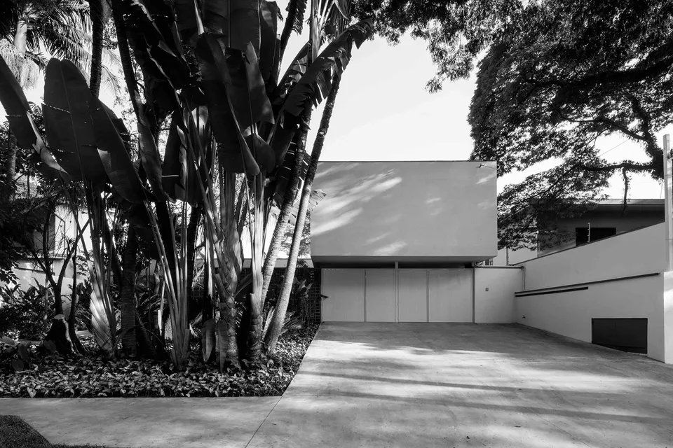 Uma foto em preto e branco de uma casa com árvores na frente