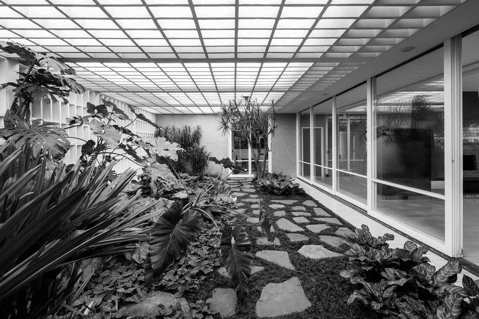 Uma foto em preto e branco de um jardim em um prédio.