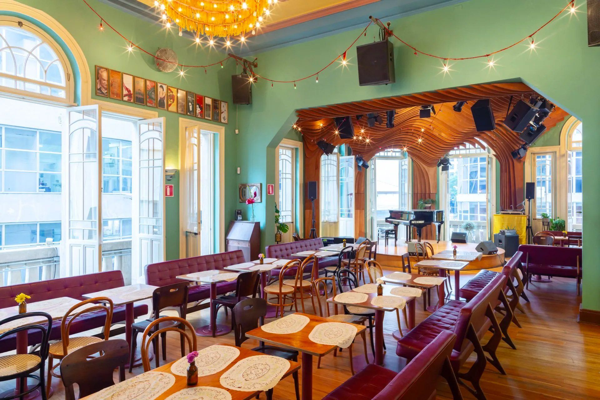 Uma grande sala cheia de mesas e cadeiras e um piano.