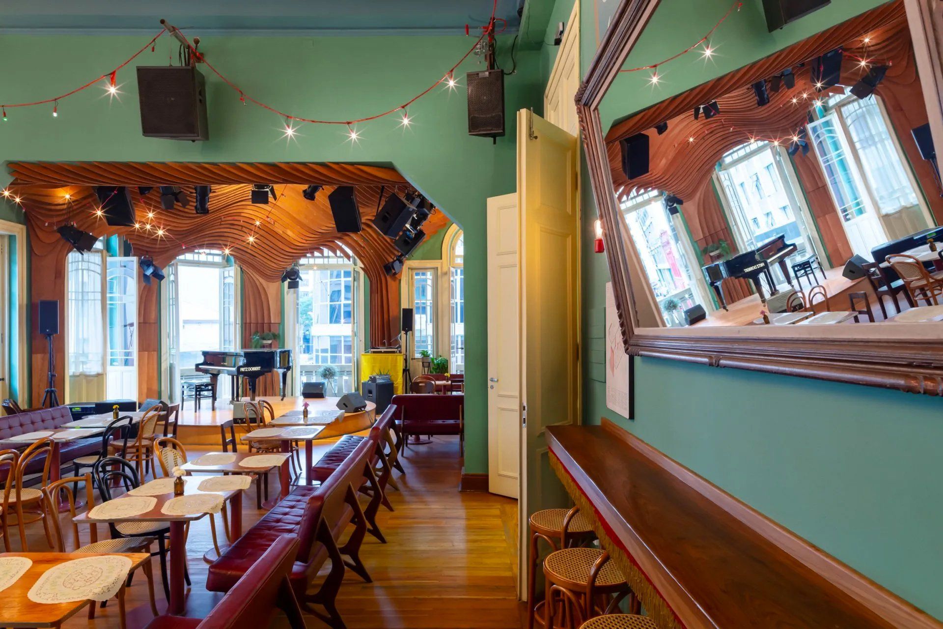 Uma grande sala com mesas e cadeiras e um espelho na parede.