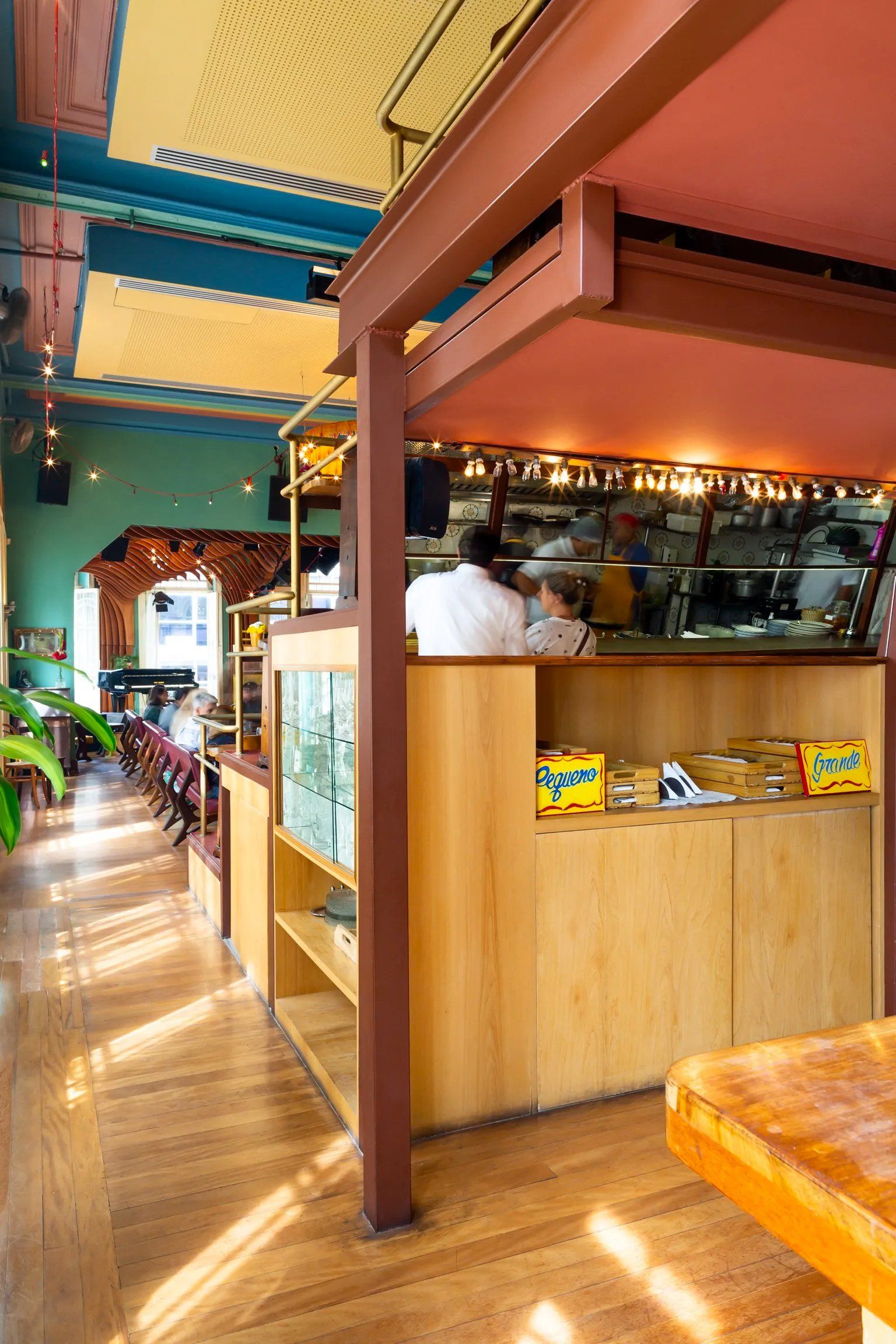 Um restaurante com teto rosa e balcão de madeira