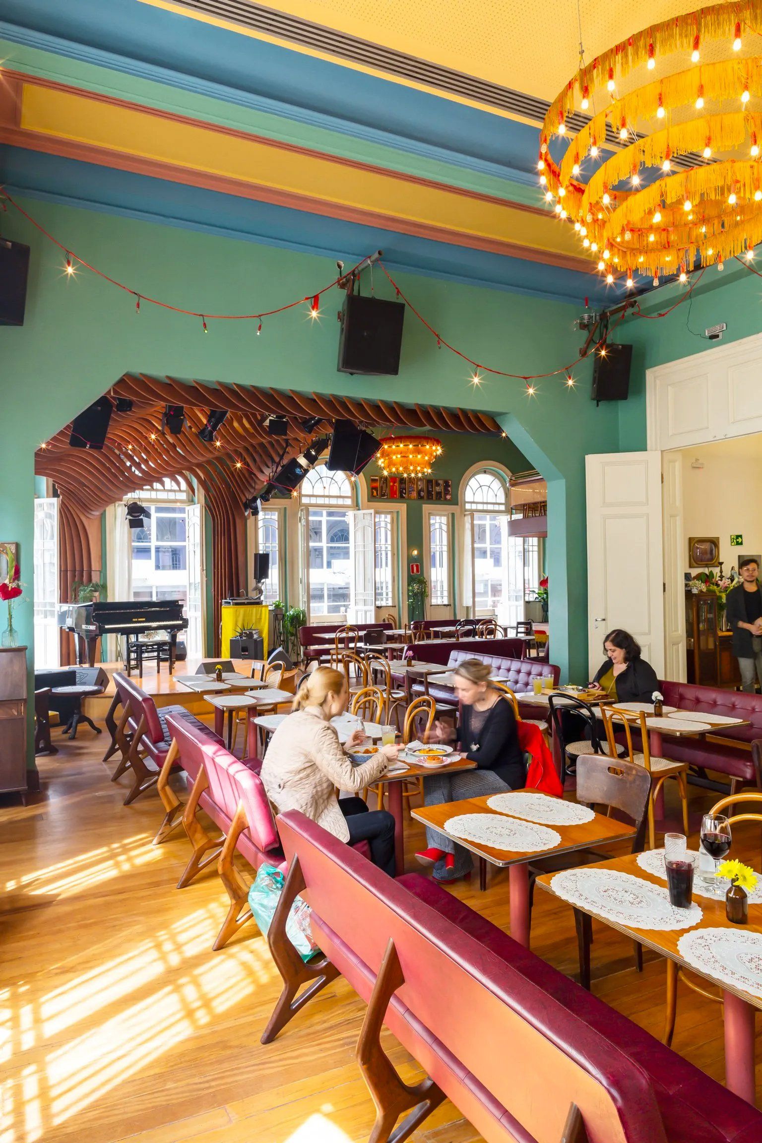 Um grupo de pessoas está sentado às mesas de um restaurante.