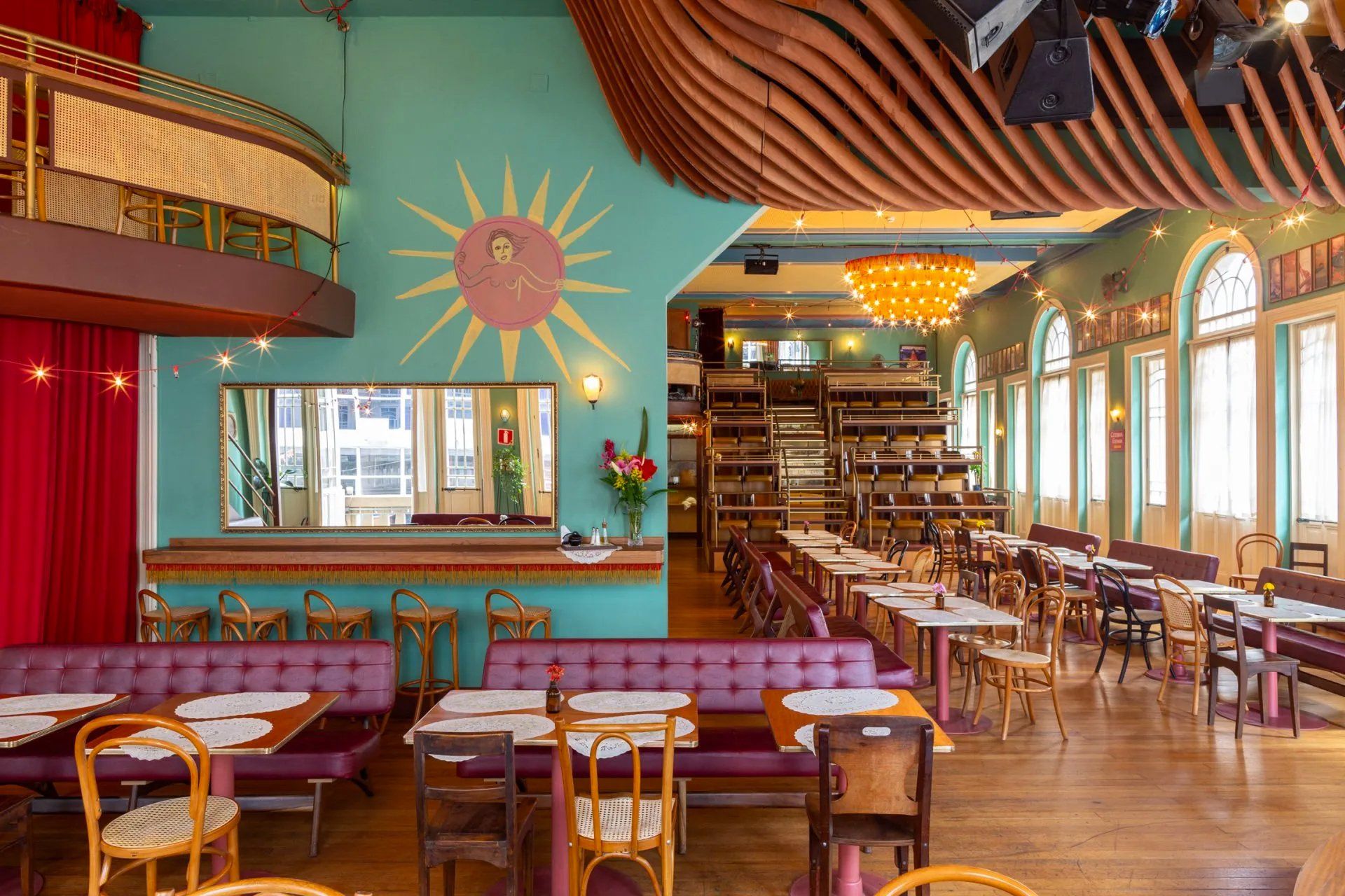 Um restaurante com mesas e cadeiras e um sol na parede.