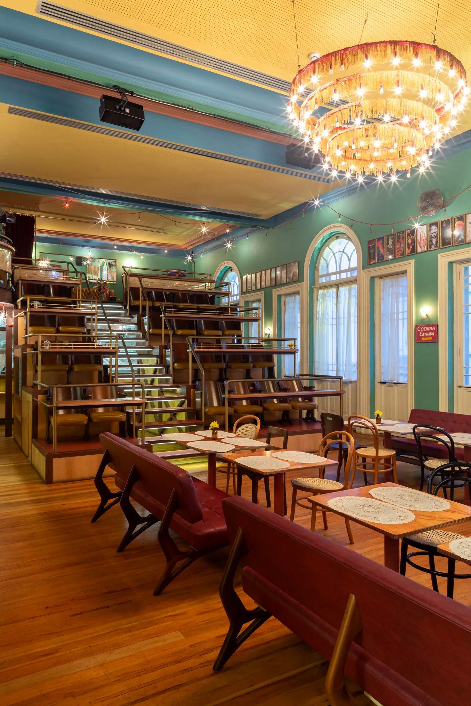 Um restaurante com mesas e cadeiras e um grande lustre