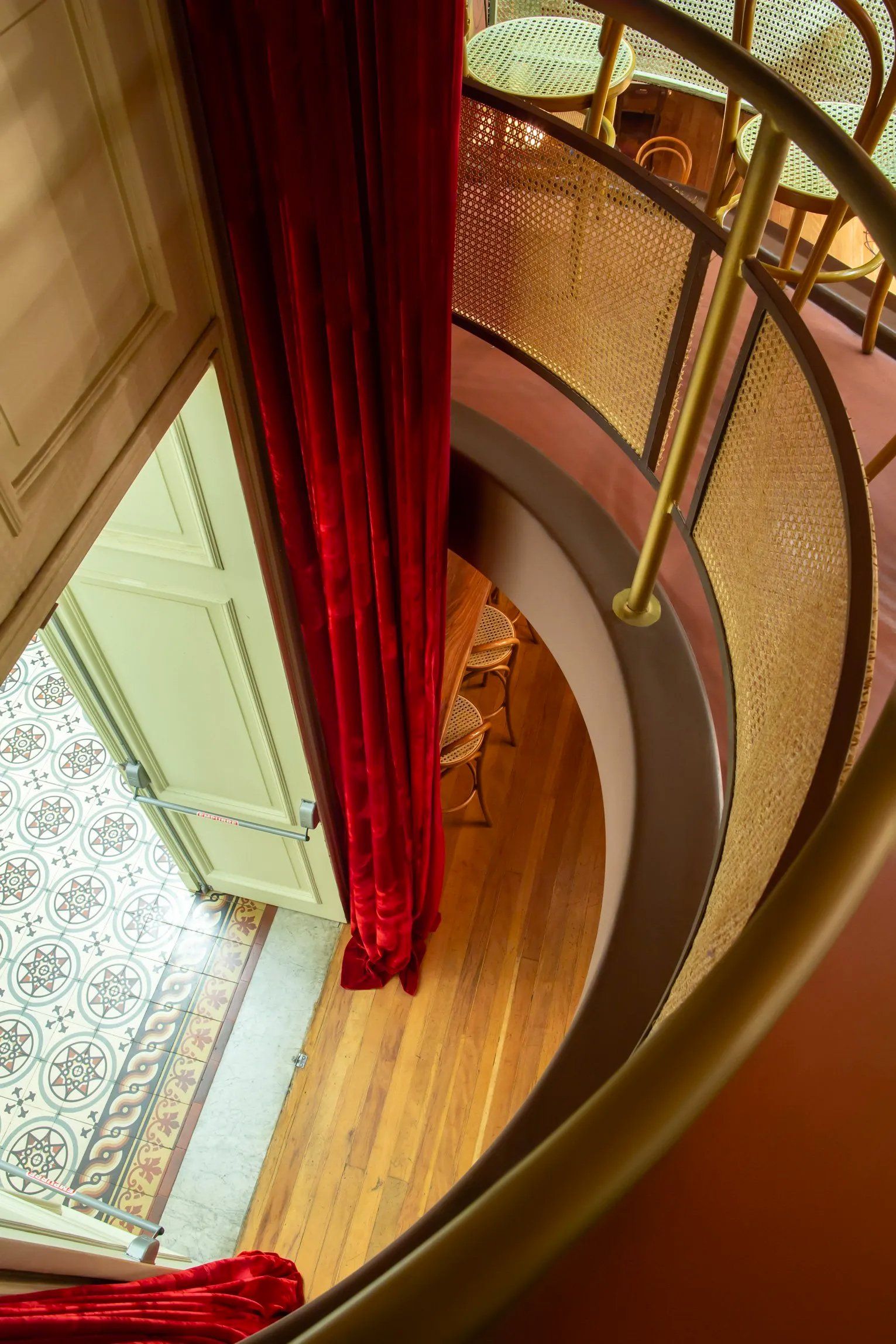 Uma vista aérea de uma escada em espiral com uma cortina vermelha