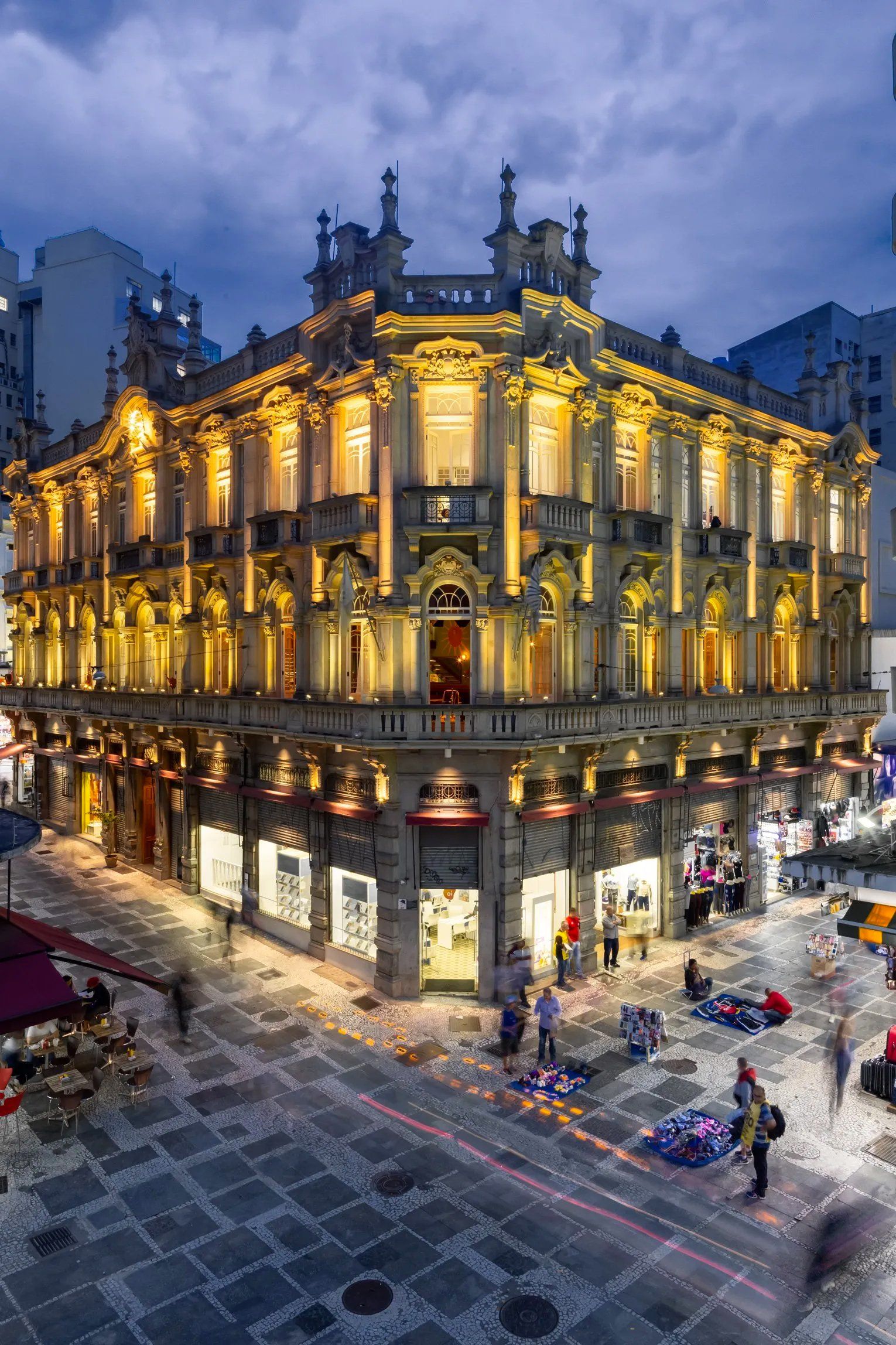 Um grande edifício com muitas janelas fica iluminado à noite.