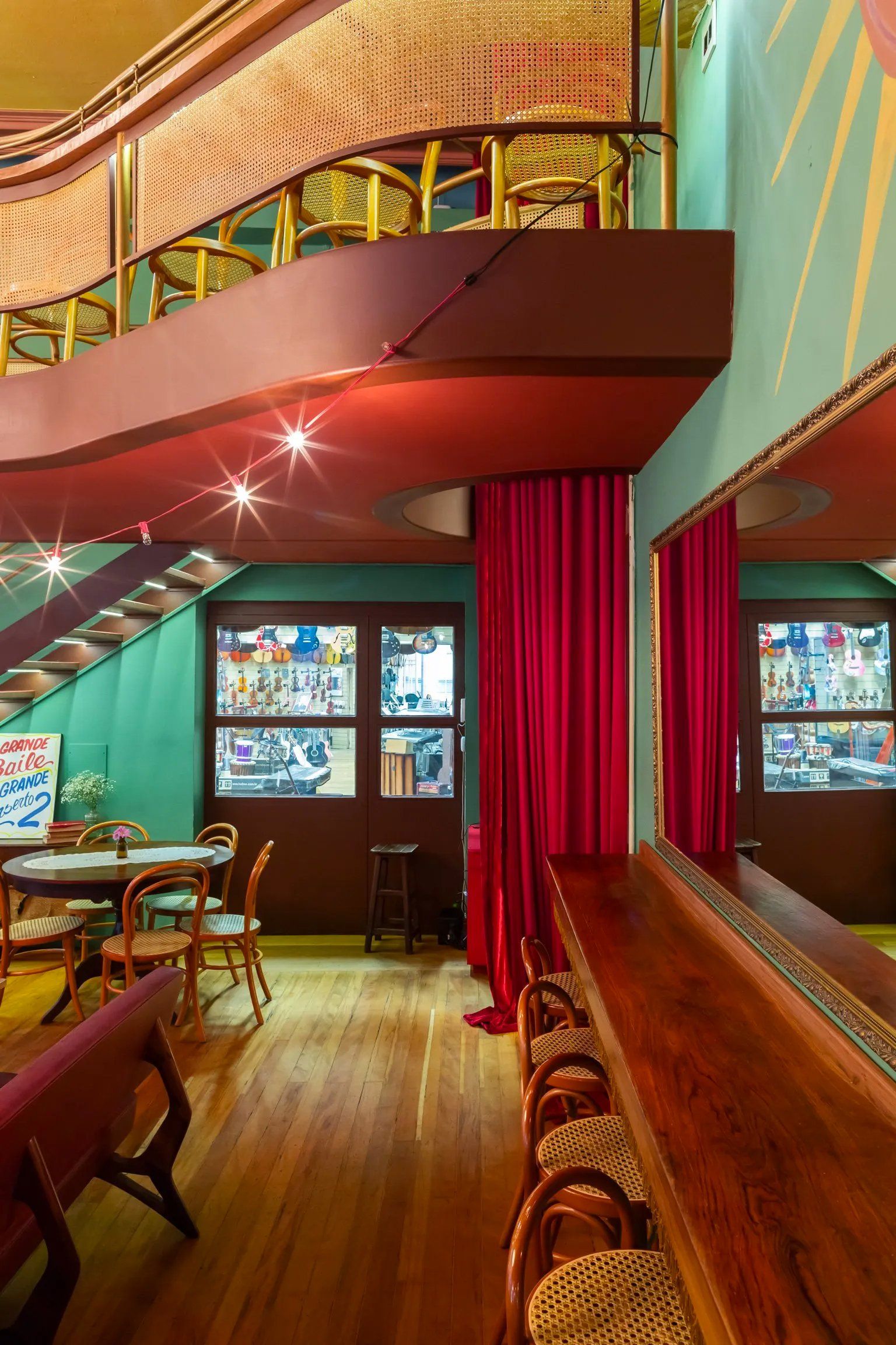 Um restaurante com mesas e cadeiras e uma cortina vermelha