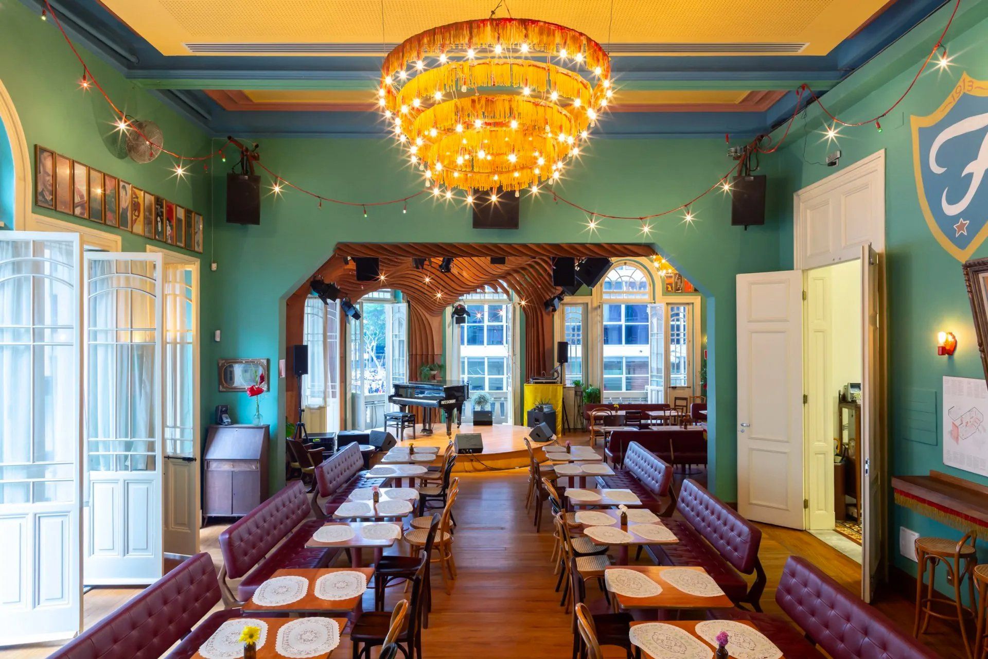 Uma grande sala com mesas e cadeiras e um lustre pendurado no teto.