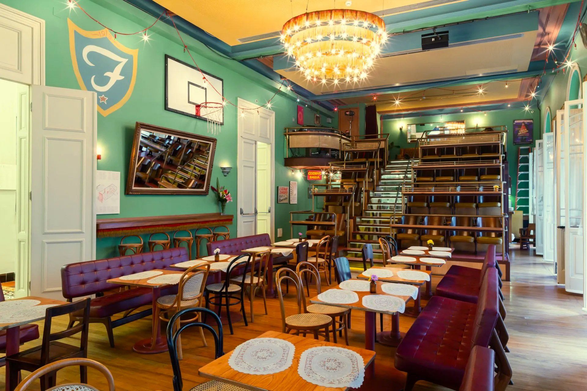 Um restaurante com mesas e cadeiras e uma cesta de basquete na parede.