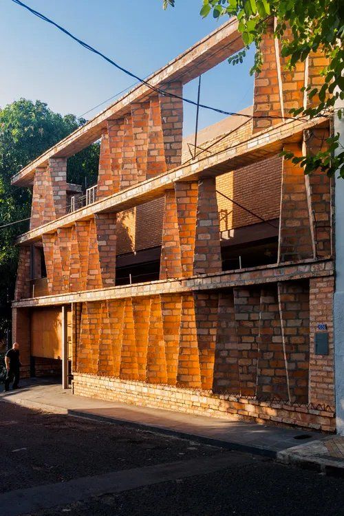 Um grande prédio de tijolos com muitas janelas