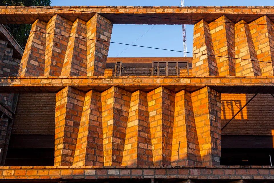 Um prédio de tijolos em construção com muitos tijolos empilhados uns sobre os outros.