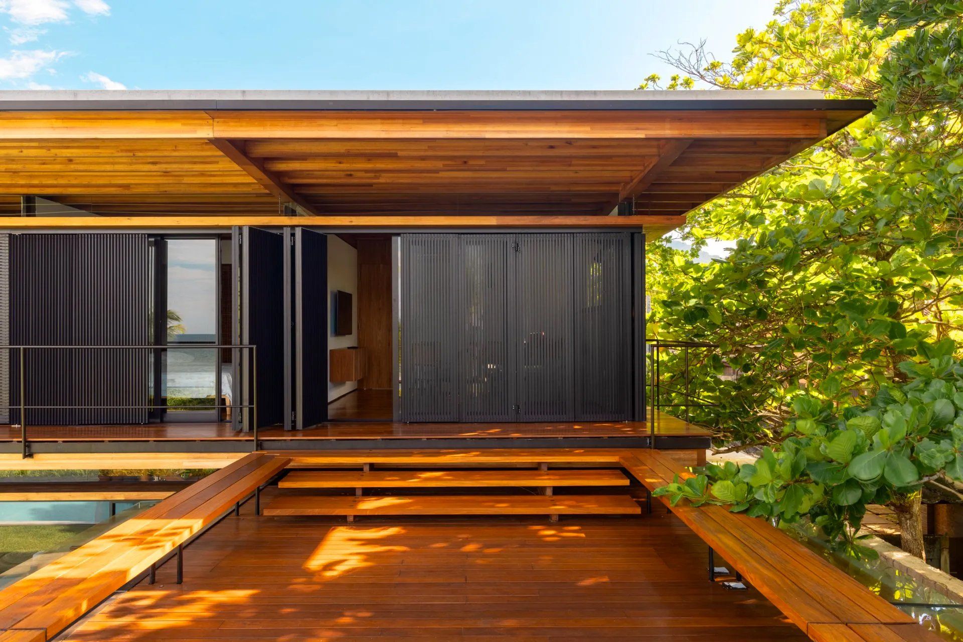 Uma casa com deck de madeira e escadas de acesso.