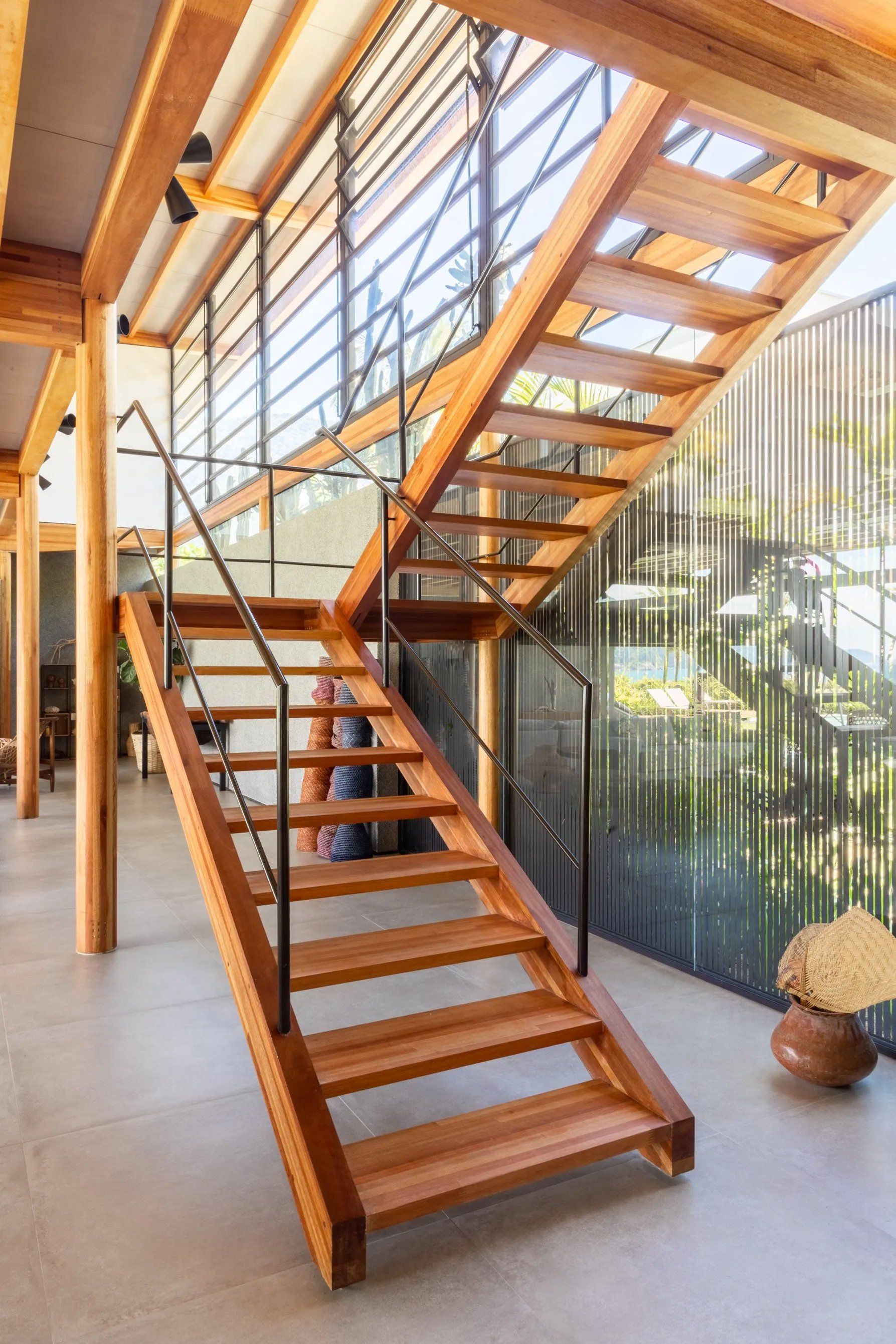 Uma escada de madeira com grade de metal em uma casa.