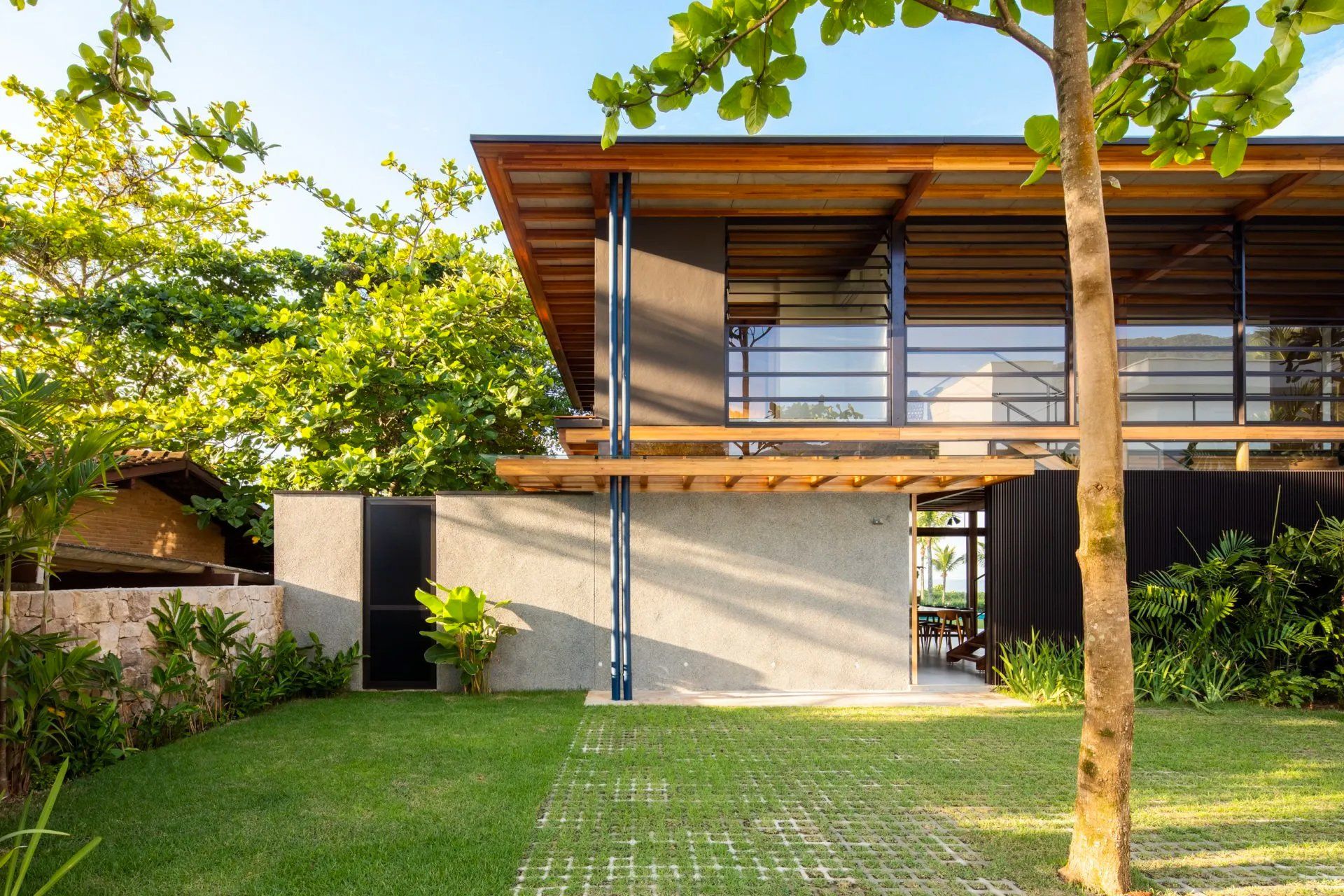 Uma casa grande com muitas janelas e uma árvore na frente.