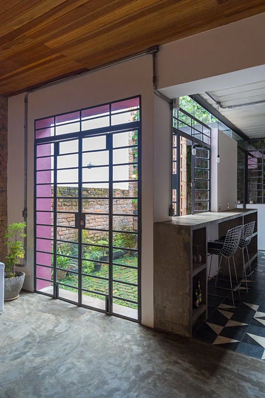 Um quarto com uma grande janela e uma porta roxa