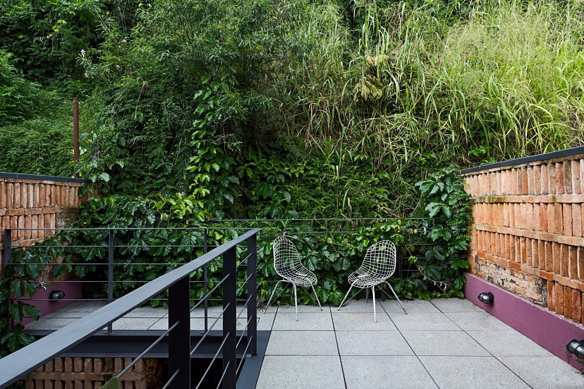 Uma varanda com duas cadeiras e uma cerca cercada por árvores.