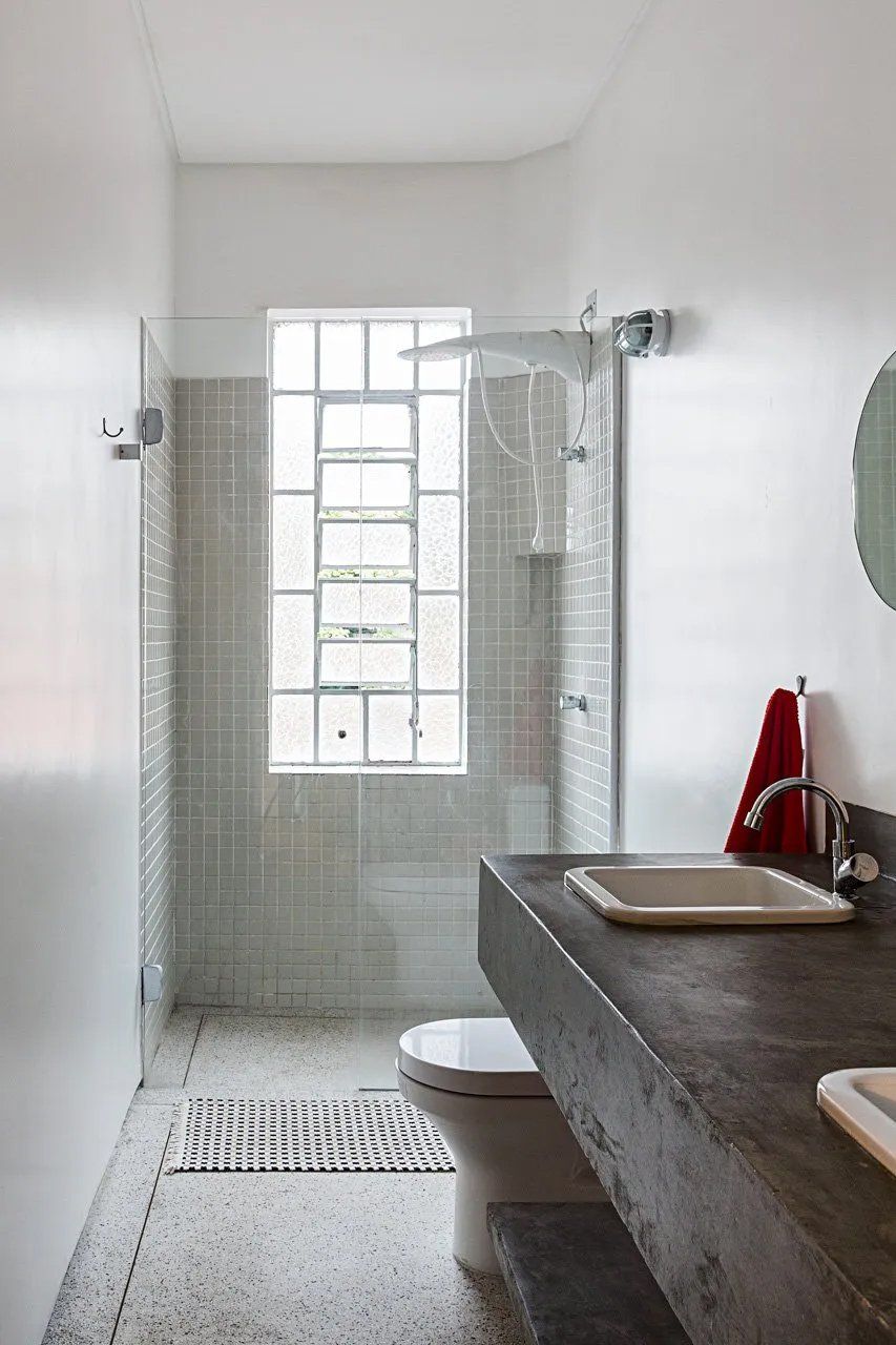 Um banheiro com vaso sanitário, pia e chuveiro.