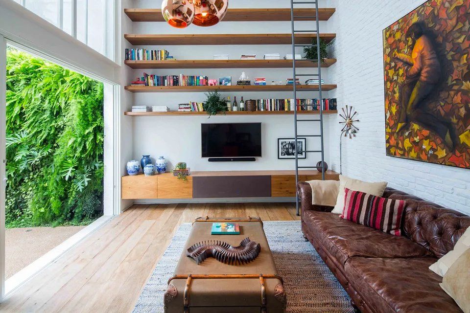 Uma sala de estar com sofá marrom e TV de tela plana