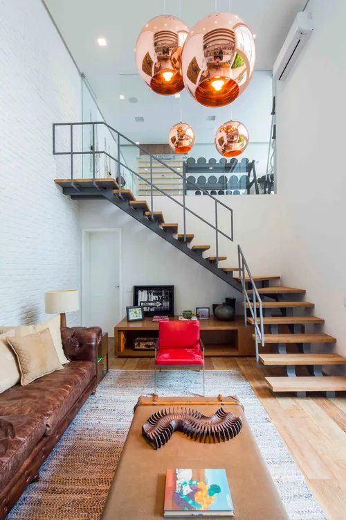 Uma sala com escada que leva ao segundo andar