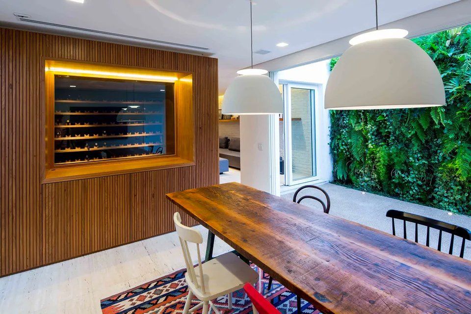 Uma sala de jantar com uma longa mesa e cadeiras de madeira.