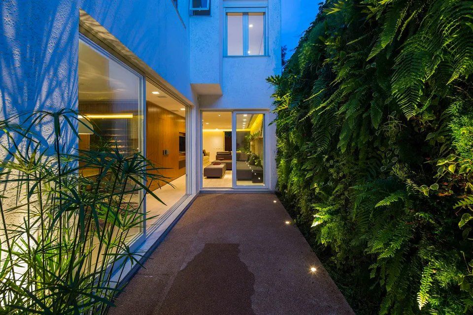 Uma passarela que leva a uma casa com uma parede verde atrás dela