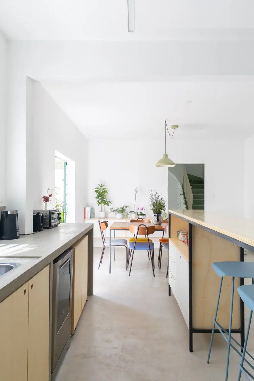 Uma cozinha com mesa e cadeiras ao fundo