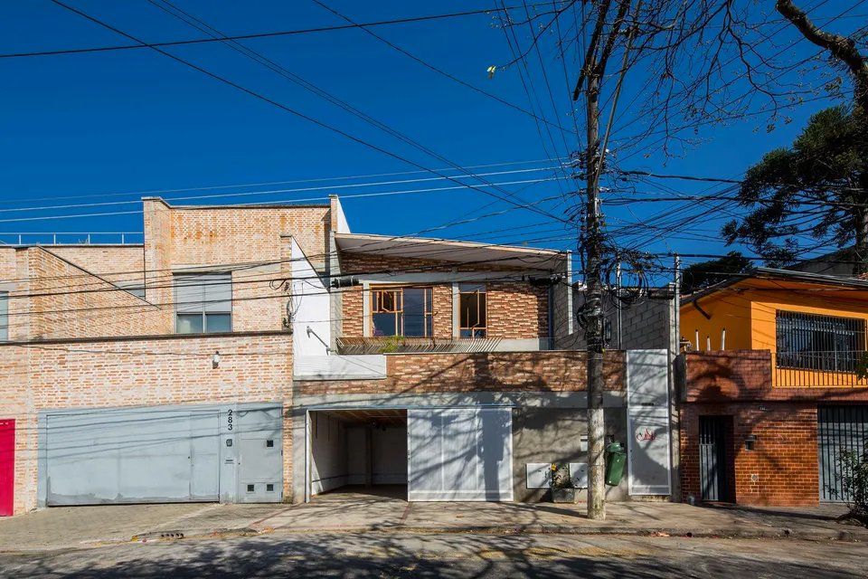 Uma fileira de casas está alinhada uma ao lado da outra em um dia ensolarado.