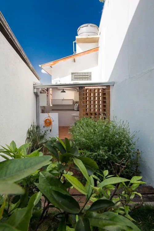 Uma casa branca com uma cozinha e um tanque de água em cima.