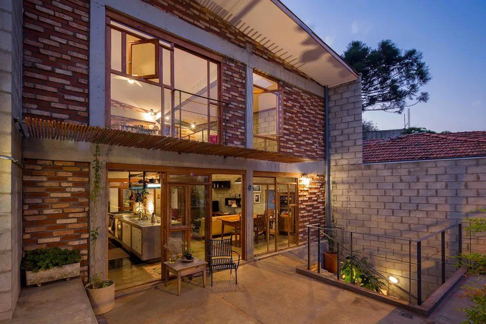 Uma casa com muitas janelas e uma parede de tijolos