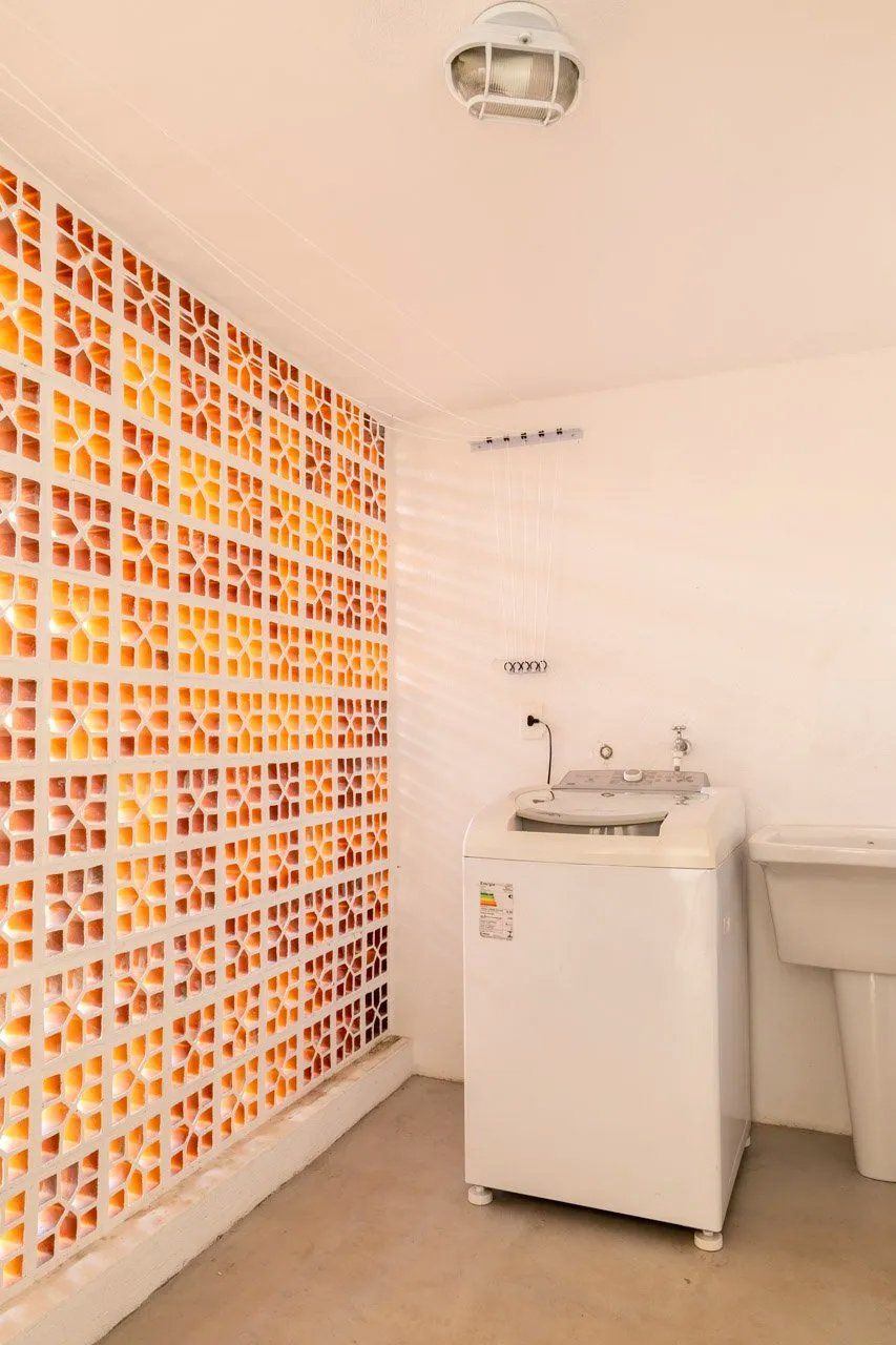 Uma lavanderia com máquina de lavar e pia