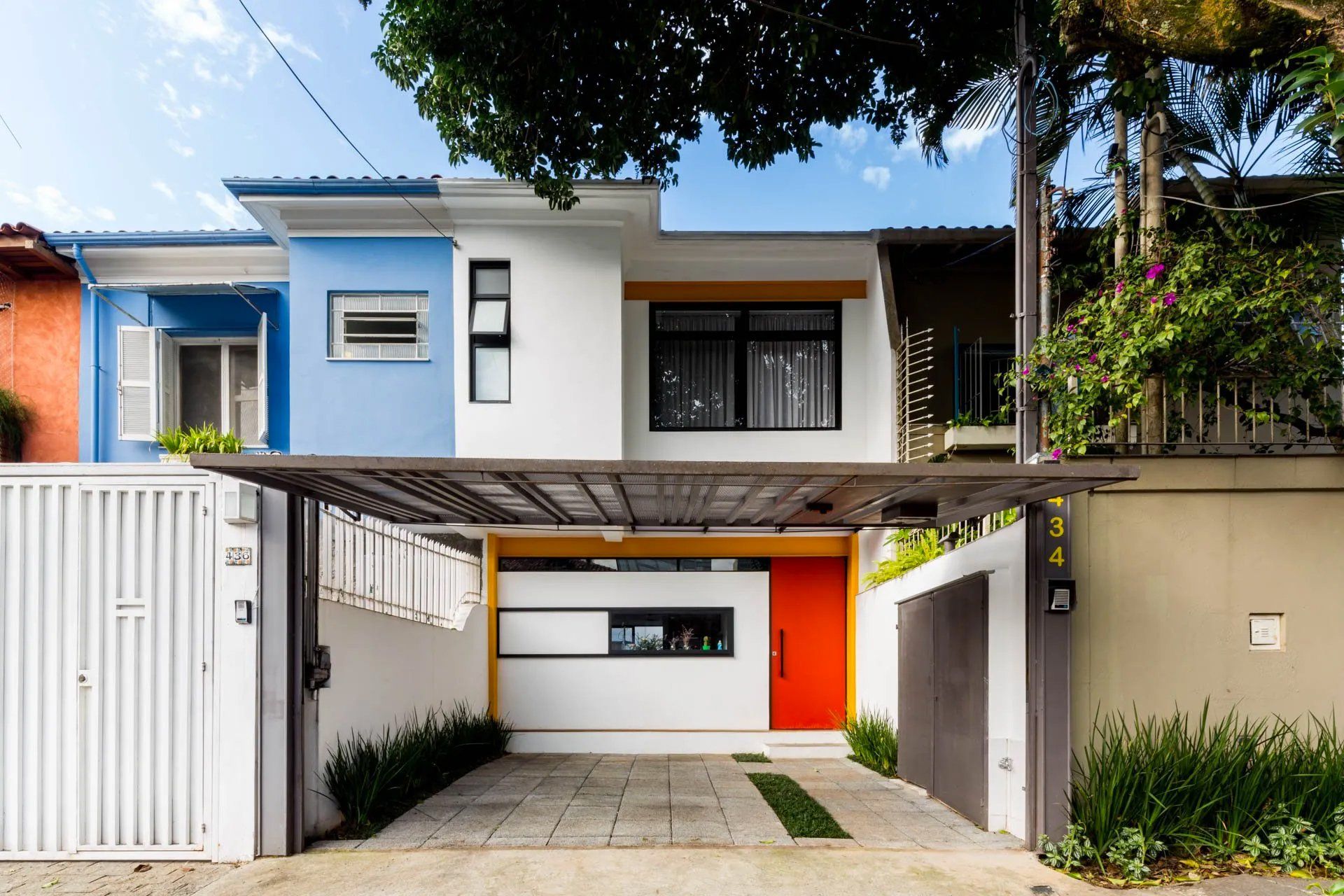 Uma casa colorida com uma cerca branca e uma entrada