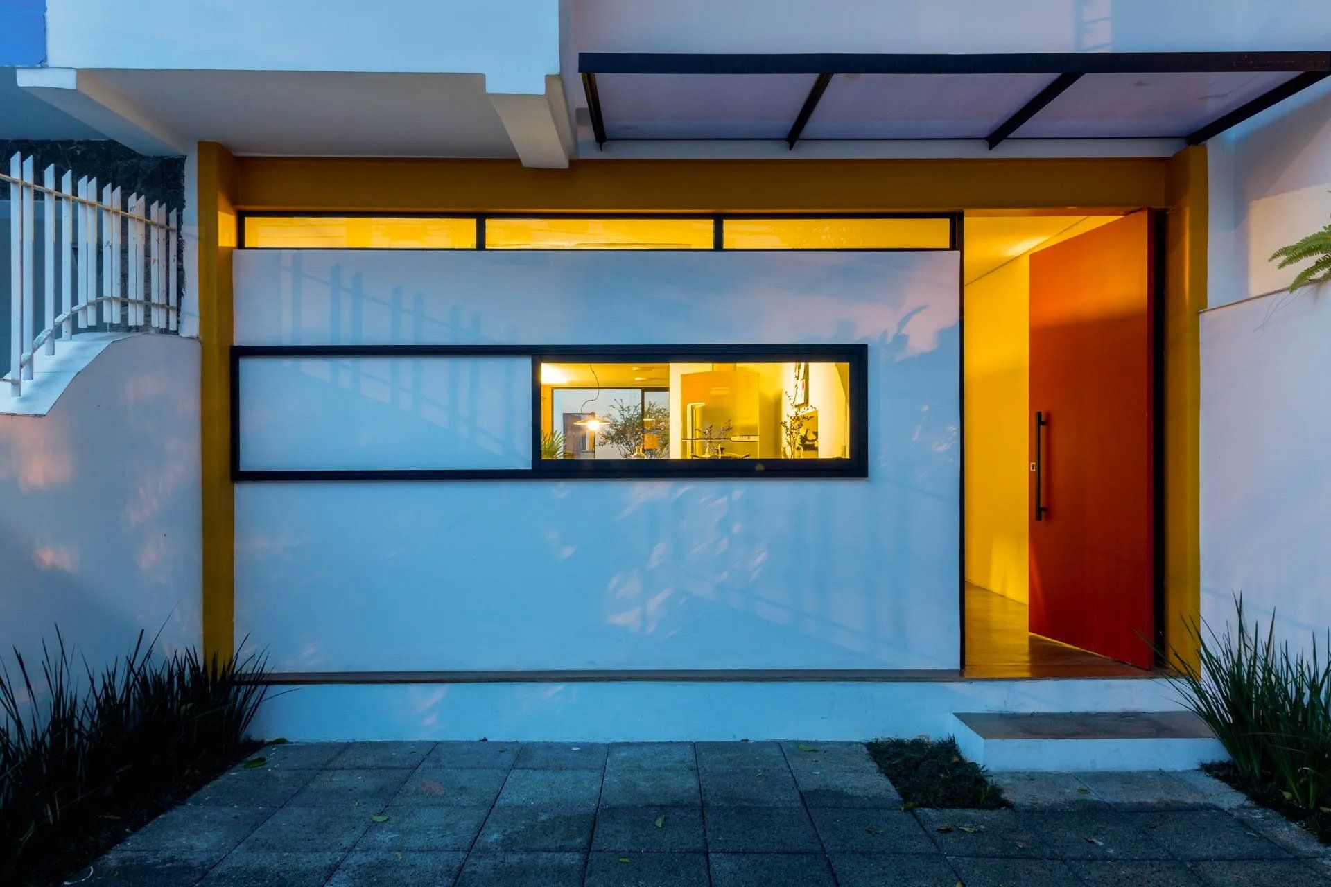 Uma casa branca com uma porta amarela e uma janela