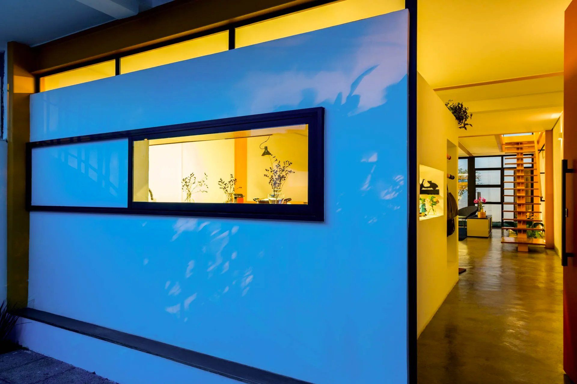 Um quarto com uma parede azul e uma janela