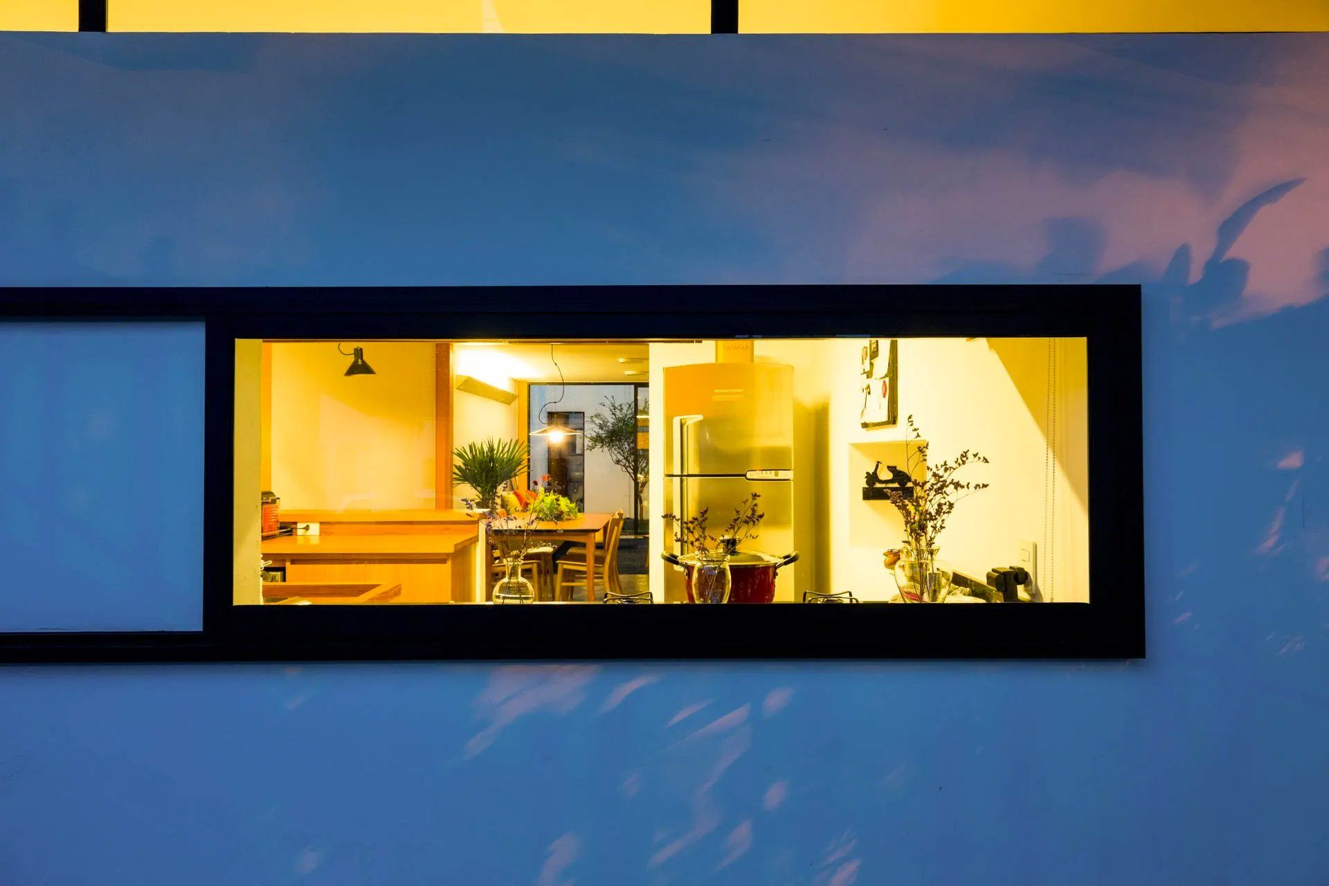 Uma foto de uma cozinha e sala de jantar através de uma janela.