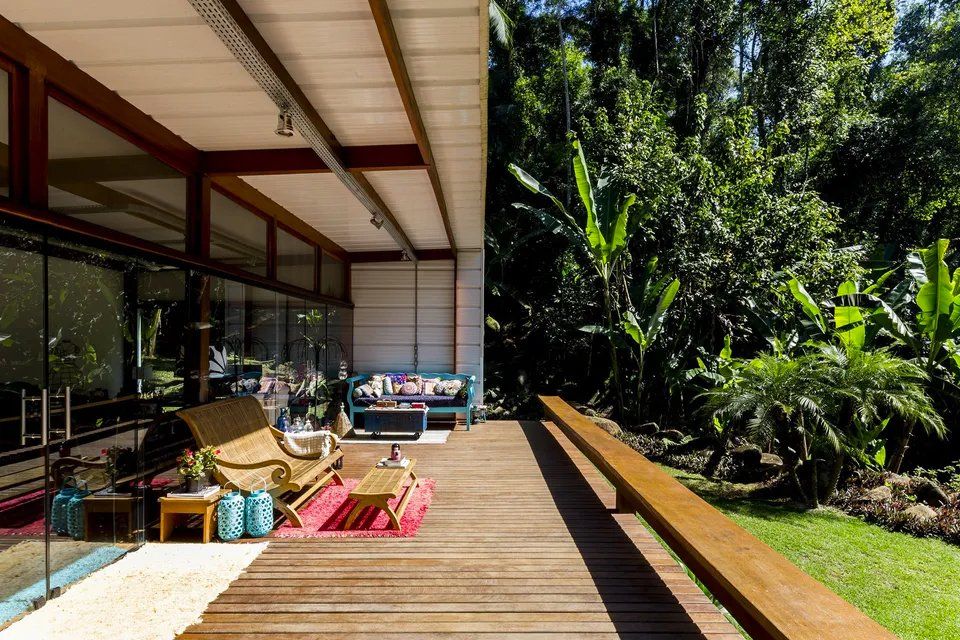 Um deck de madeira com um sofá e cadeiras