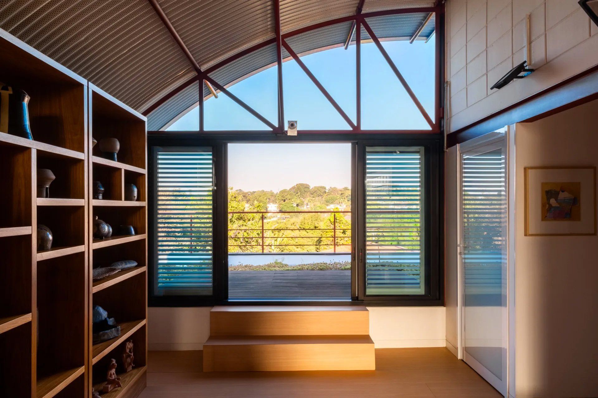 Uma sala com muitas prateleiras e uma grande janela