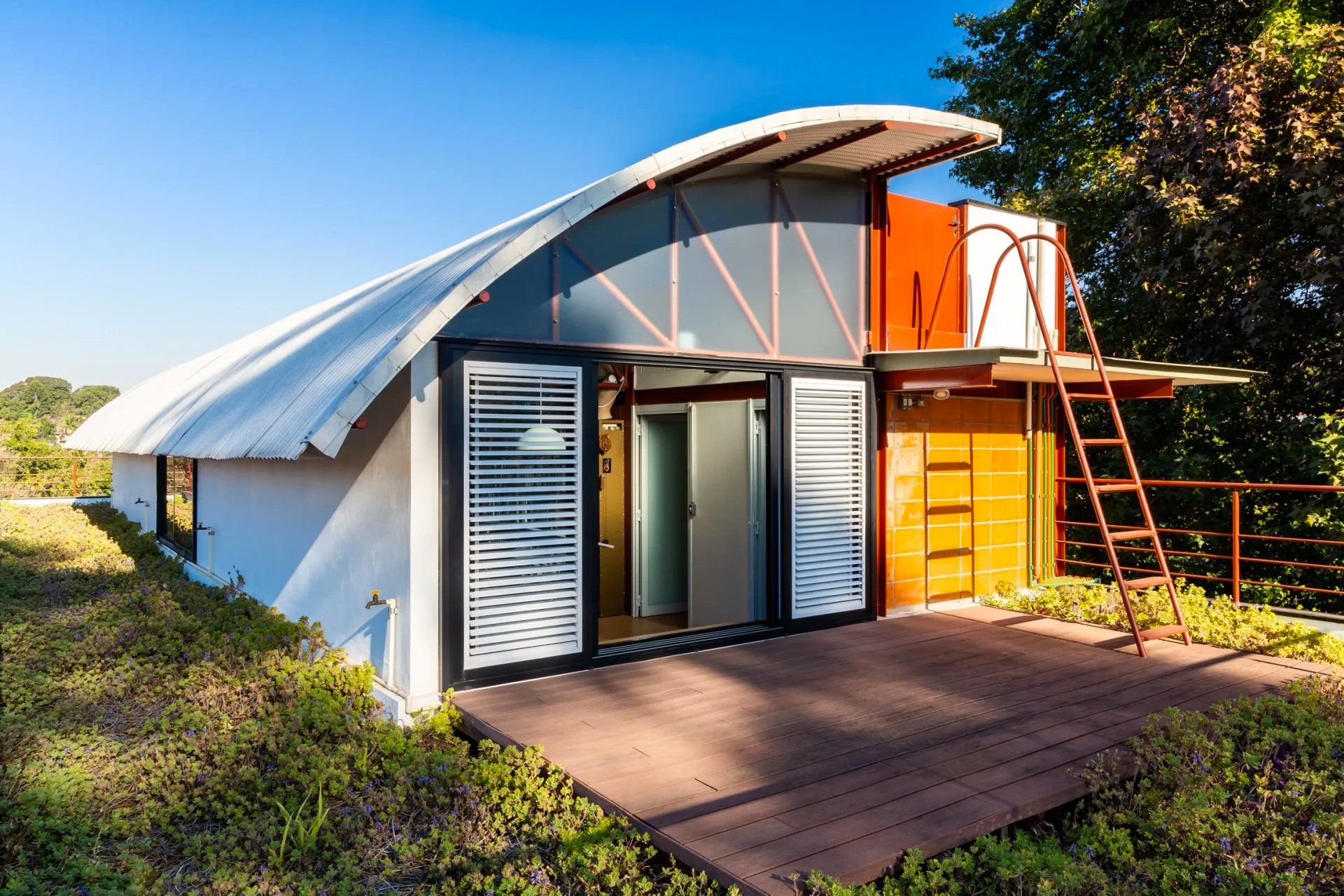 Uma pequena casa com telhado curvo e escadas