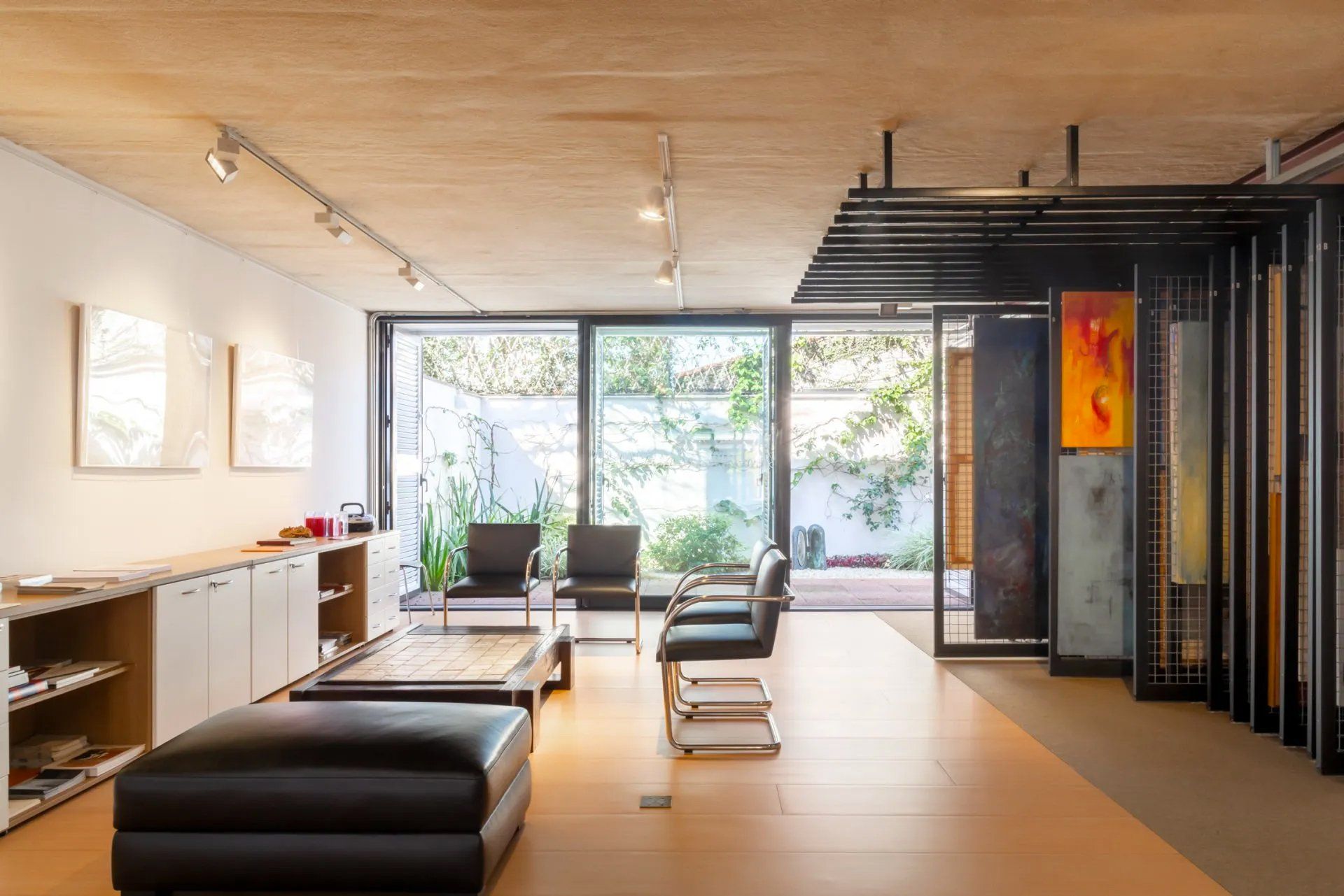 Uma sala de estar com muitas janelas e móveis