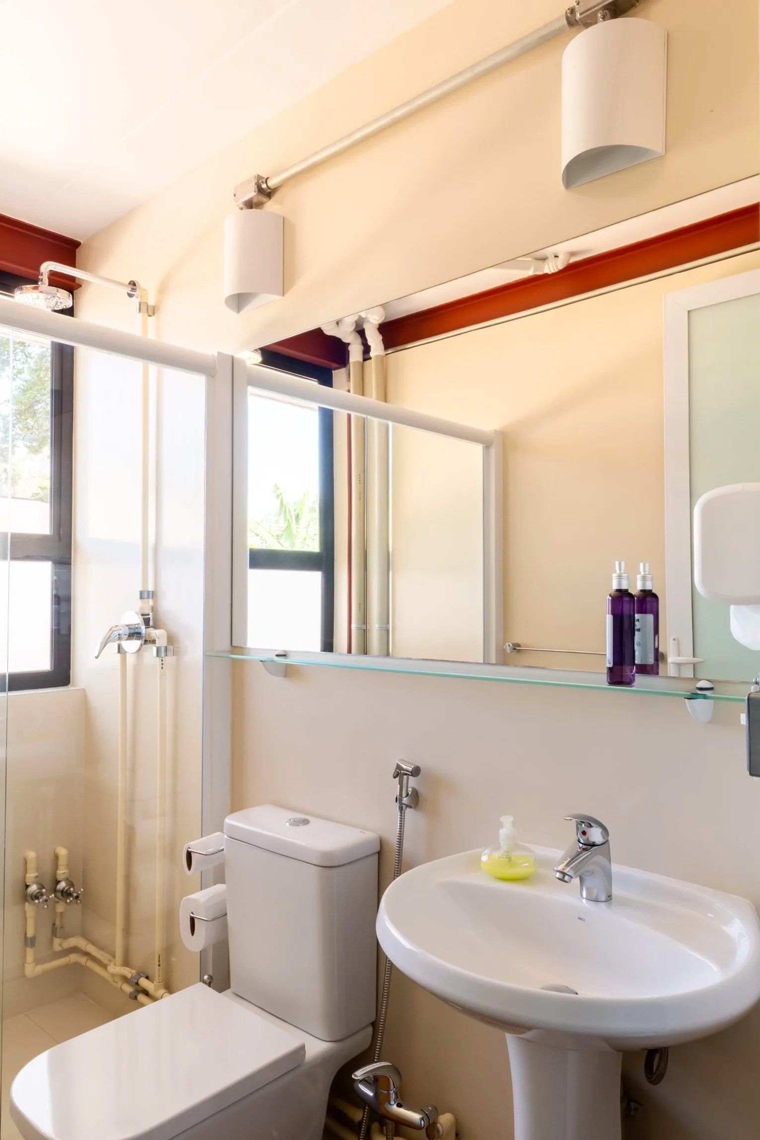 Um banheiro com vaso sanitário, pia e espelho.