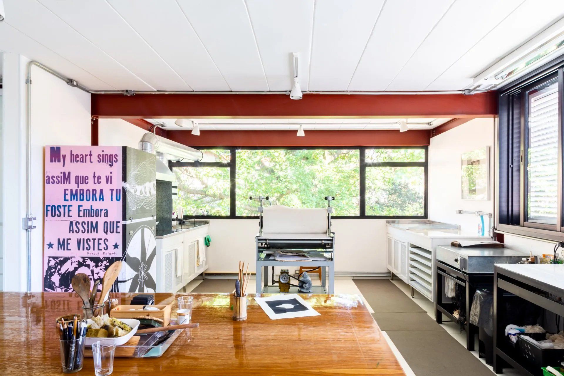 Uma sala grande com muitas janelas e uma mesa de madeira.