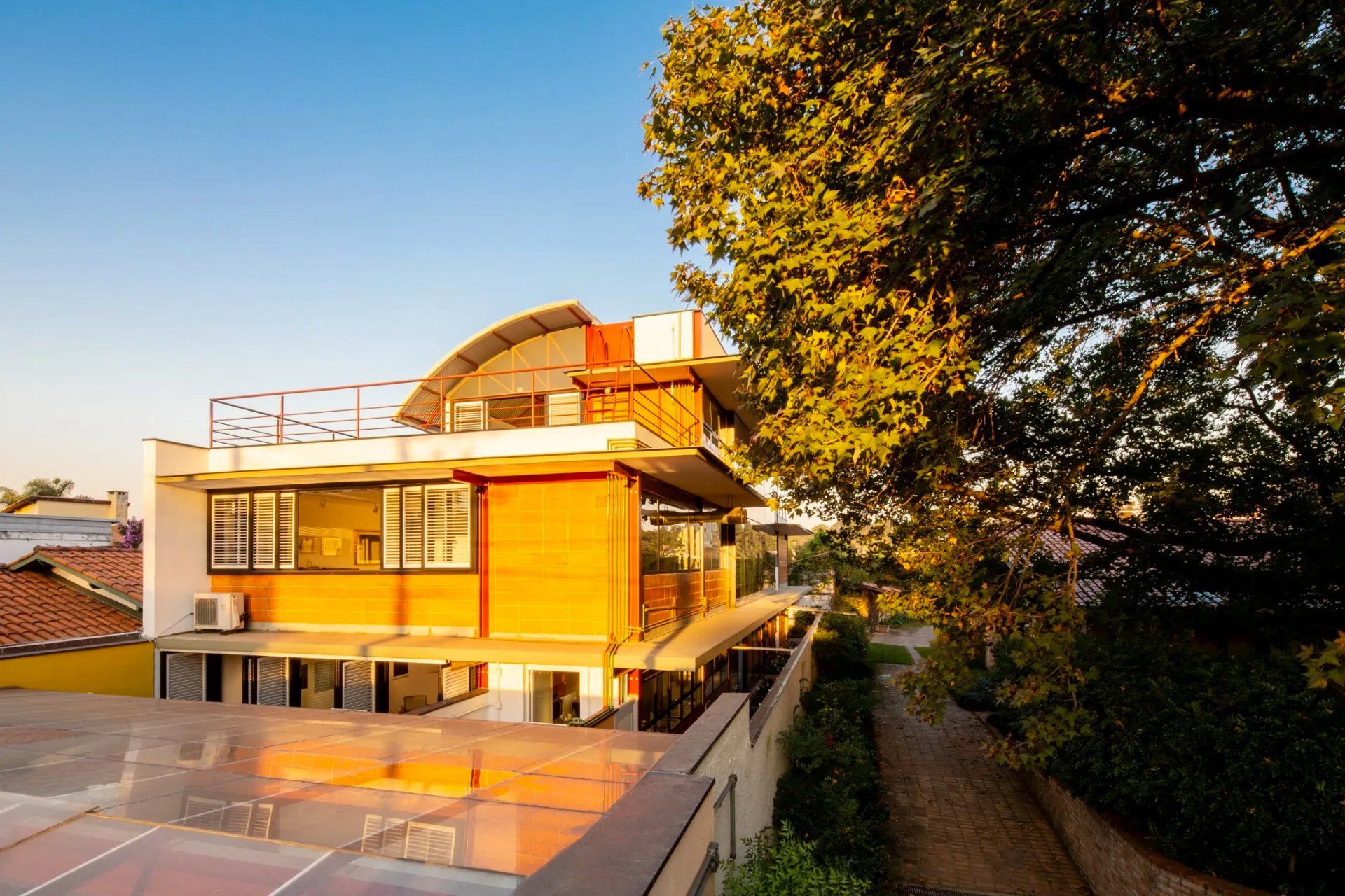 Uma grande casa laranja com uma árvore na frente