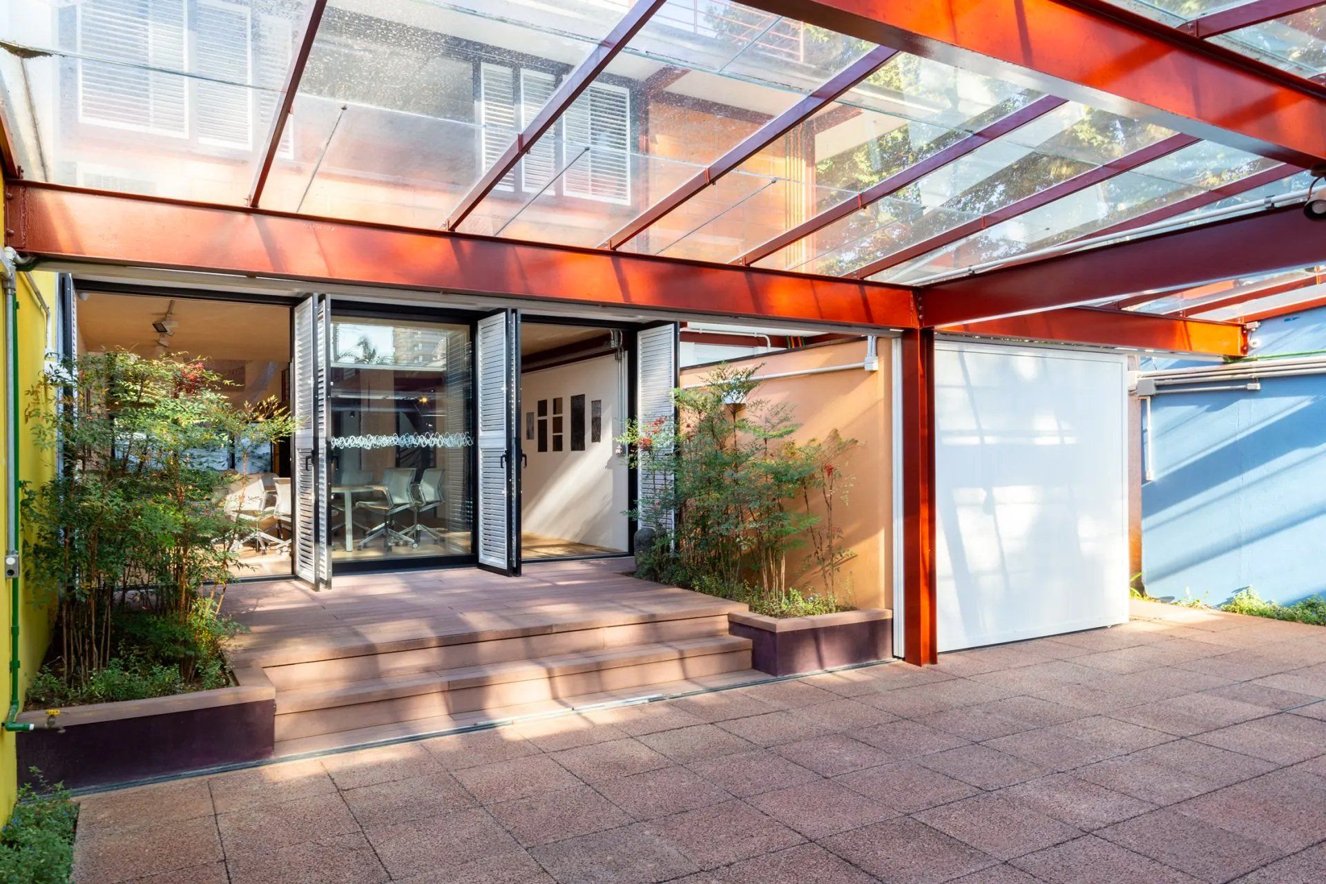 Um prédio com telhado de vidro e escadas que levam até ele.