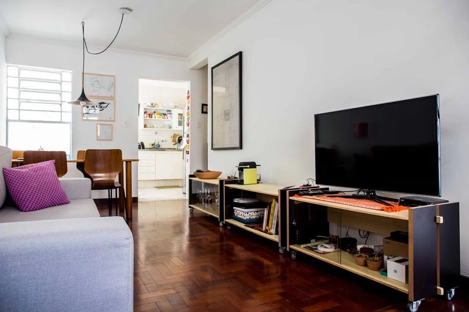 Uma sala de estar com sofá e TV de tela plana