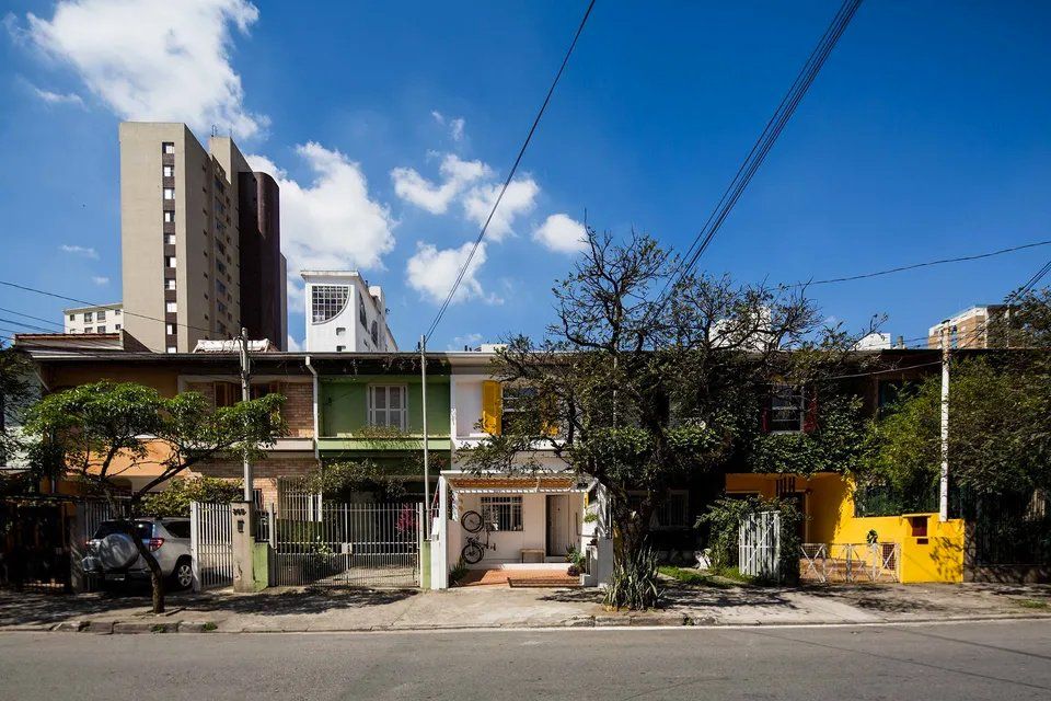 Uma fileira de casas coloridas está alinhada ao lado de uma rua da cidade.
