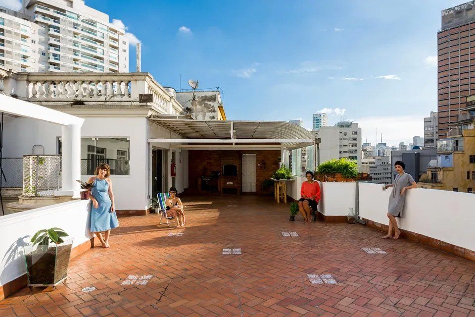 Um grupo de pessoas está em um terraço na cobertura.