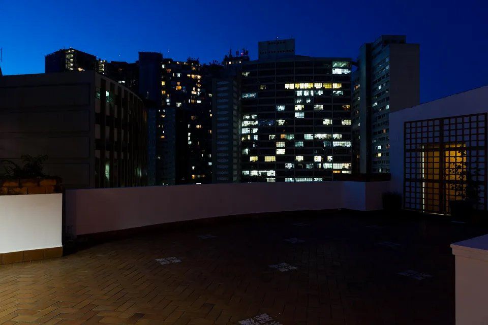 Um telhado com vista para uma cidade à noite