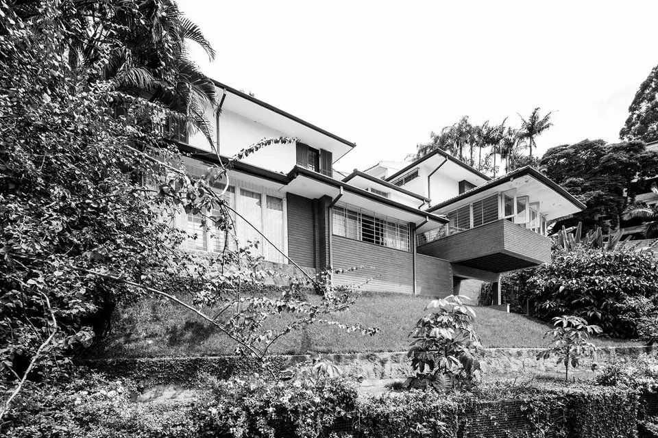 Uma foto em preto e branco de uma casa em uma colina